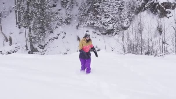 Молодая женщина бегает по снегу в зимней одежде — стоковое видео