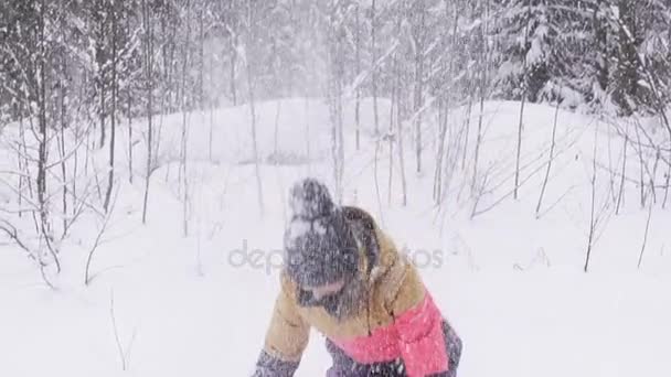Щаслива мила дівчина грає зі снігом на відкритому повітрі, кидаючи його руками, красива жінка посміхається з піднятими руками, молода підліток-жінка в барвистому пальто, Різдвяні зимові канікули — стокове відео