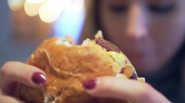 Kadın kafede hamburger yemek