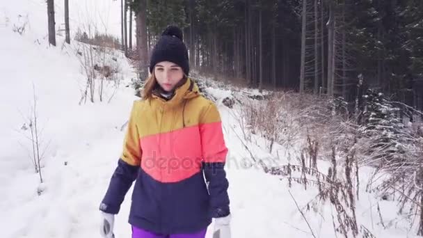 Perfil de close-up da jovem caminhando na floresta de inverno durante a queda de neve — Vídeo de Stock