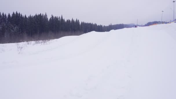 Ung kvinna i ljusa vinterkläder glidande på röret på Park på backarna i skidorten — Stockvideo