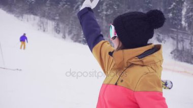Sportif kadında genç gülümseyen ve birilerini arayıp elini sallayarak Kayak gözlüğü