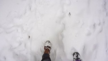 Bacaklar erkek ve kadın kış Boots birbirine yakın karda yürüme.