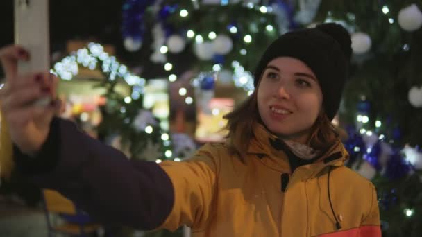 Jonge vrouw nemen van foto met mobiele telefoon op de kerstmarkt — Stockvideo