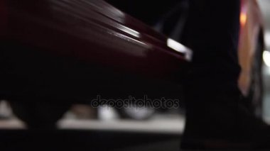 Adam araba sürücüleri tarafında biniyorlar. Closeup görüntülemek aşağıdan, bacaklar Boots.