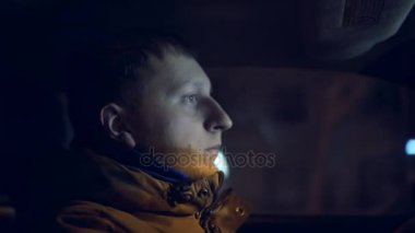 Gece araba sürüş genç adam. İçeriden görüntülemek.