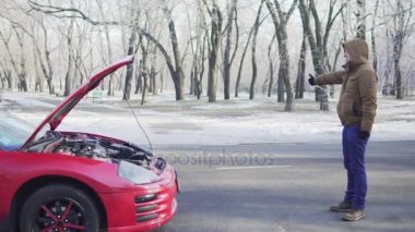 Çekici bir genç adam ona yakın aşağı kırık arabası ile bir yolda otostop