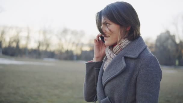 Деловая женщина ходит и разговаривает по телефону — стоковое видео