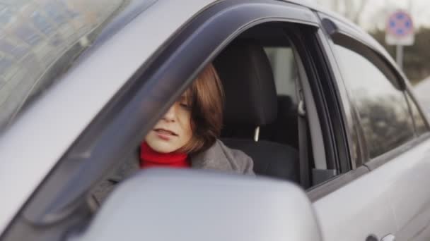 Vista de cerca de la mujer de negocios con abrigo gris saliendo del coche — Vídeo de stock