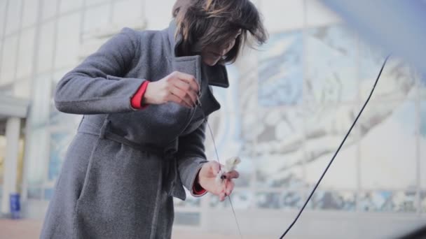 Mujer de negocios comprueba el nivel de aceite en el coche mirando debajo del capó en la calle. Volver a poner la varilla de inmersión — Vídeos de Stock