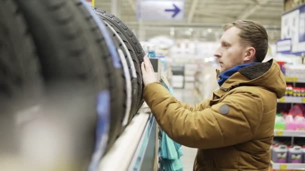 Mann wählt neue Reifen im Geschäft — Stockvideo