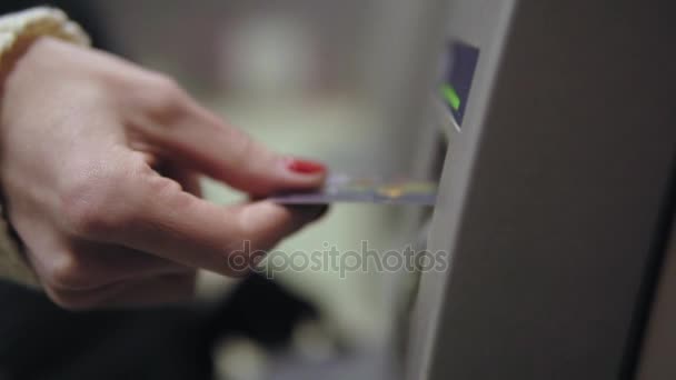 Женщины руки с покрашенными красными ногтями вставляя кредитную карту в банкомат, используя его и принимая обратно. Красивый маникюр — стоковое видео
