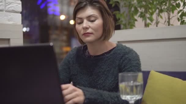 Vrouw die werkt op haar laptop tijdens haar doorbraak — Stockvideo