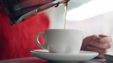 Kadın çay bir fincan içine dökülen.