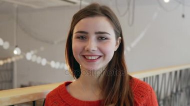 Kahve Dükkanı arka plan kamerada sevimli genç kadın gülümsüyor yakın çekim