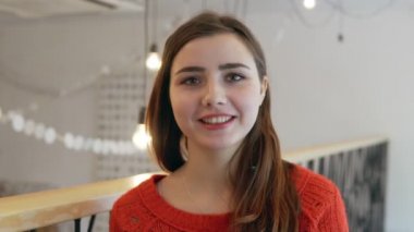Kahve Dükkanı arka plan kamerada sevimli genç kadın gülümsüyor yakın çekim