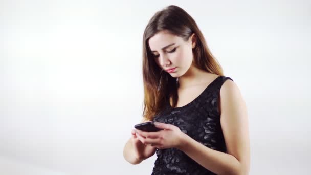 Jovem mulher usando telefone inteligente móvel no fundo branco — Vídeo de Stock