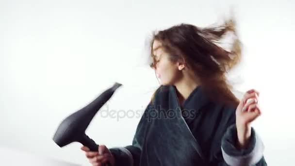 Images de belle jeune femme chantant au sèche-cheveux isolé sur le fond blanc — Video