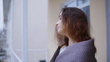 Genç adam kız arkadaşı battaniye sahil manzaralı kapalı terasta ayakta çay getir