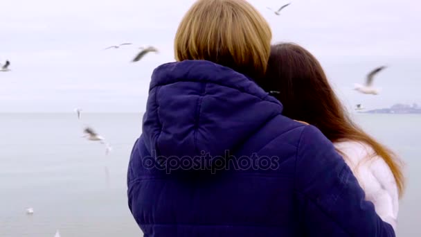 Coppia giovane sulla spiaggia di mare. Coppia d'amore che si abbraccia sulla spiaggia e si tiene per mano. Gabbiani che volano sullo sfondo — Video Stock