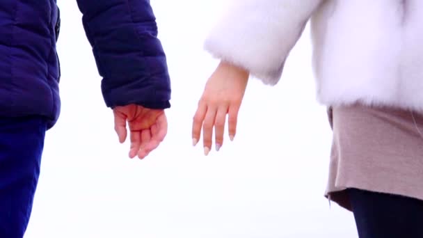 Vista de perto das mãos do jovem casal na praia. De mãos dadas — Vídeo de Stock