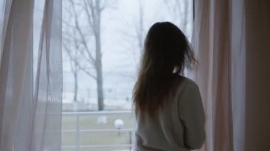 Genç kadın sabah ve terasa dışarı çıkıp kapıyı açar