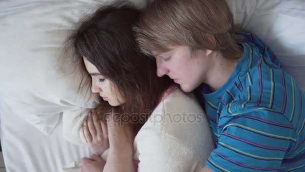 Beautiful couple sleeping together in the bed. The man is embracing the woman — Stock Video