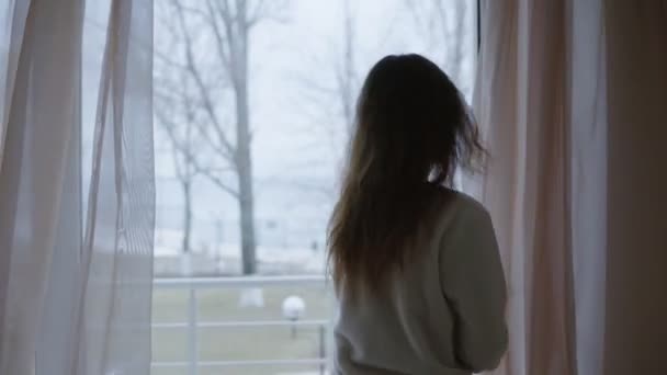 Молодая женщина открывает дверь утром и выходит на террасу — стоковое видео