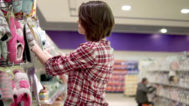 Esmer kadın terlik süpermarkette seçme. Rahat homewear seçme