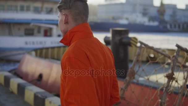 Travailleur du port en uniforme orange marche sur le site de Cargo Harbor. Mouvement lent — Video