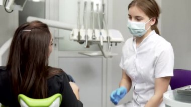 Ortodonti Kliniği diş hekimi istişare adlı genç bayan hasta. Sonra muayene için doktorlar tavsiye dinleme.