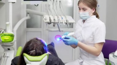 Genç kadın dişçi maske ve eldiven diş Uv ışık cihazları polimer sertleştirme için kullanma