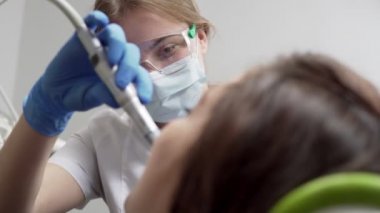 Eldiven ve maske hastalar diş Kliniği sondaj genç kadın diş hekimi