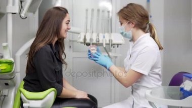 Doktor Diş modeli closeup elinde tutuyor. Diş hekimi çene hasta bir maket gösterir. Çene modeli. Çene kemikleri. Öznitelikleri ve bir dişçi ofisinde ayrıntıları.