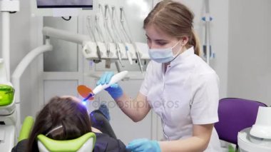 Genç kadın dişçi maske ve eldiven diş Uv ışık cihazları polimer sertleştirme için kullanma