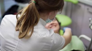 Bir peçeteye onun hasta için çekici genç kadın doktor. Ağız hijyeni ve diş bakımı: doktor diş hekimi diş Kliniği hastada ile çalışma. Sağlık kavramı.