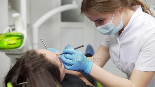 Молода жінка-стоматолог вивчає зуби пацієнтів. Здорові зуби та здоров'я зубів . — стокове відео