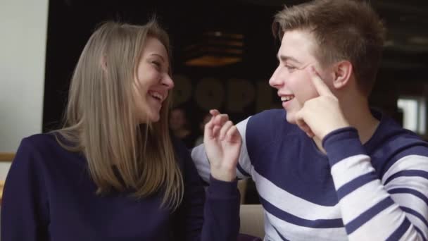 Joven pareja atrayente está sentado en el café, hablando y riendo — Vídeo de stock