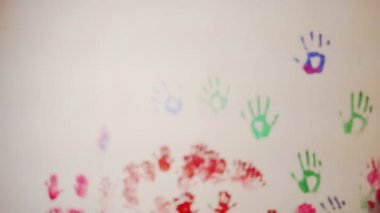 Mutlu anne ve sevimli oğlu birlikte onların renkli el izleri duvara terk eğleniyor. Genç, mutlu bir aile. Anne ve çocuk kavramı