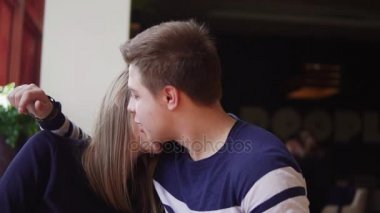 Kafede masada oturan, birbirlerine kucaklayan ve Slowmotion konuşmak genç Çift.