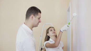 İki oda ve beyaz boya silindiri ile boyama duvar dekorasyon. Aile taşımak için onların yeni daire hazırlıyoruz.