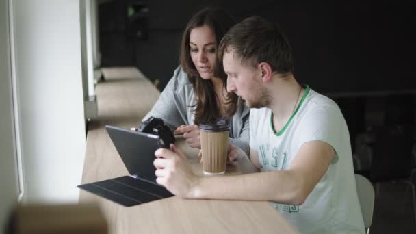 Vergadering in foto agentschap werkzaam. Client en fotograaf de volgorde bespreken en kijken naar de resultaten van het werk. Schot in 4k — Stockvideo