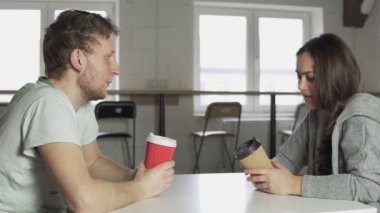 Kahve-to-go kağıt bardak içme ve söz, iki arkadaş kafe, masada oturuyor. 4 k'dan fazla vurdu