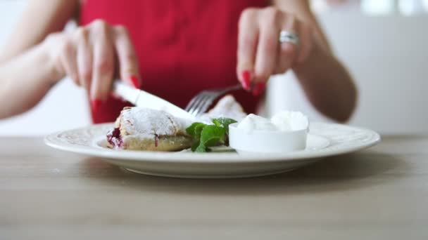 Fille méconnaissable en robe rouge manger strudel dessert au restaurant à l'aide d'une fourchette et un couteau. Coup de ralenti . — Video