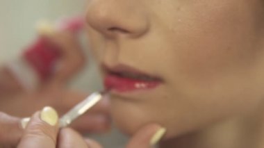 Kırmızı ruj bir fırça kullanarak uygulama sanatçı olun. Closeup görünümü. Slowmotion atış
