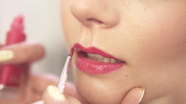 Maquillaje artista aplicar lápiz labial rosa con un cepillo. Vista de cerca. Disparo en cámara lenta — Vídeo de stock