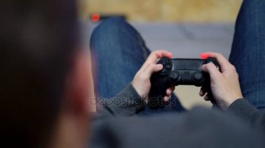 Closeup görünümünü video oyun evde oynarken ellerini mans. Çekim ve oyun kumandasını kullanarak kontrol etmek. Xbox ve Playstation. Kablosuz oyun kontrolcü. Slowmotion atış