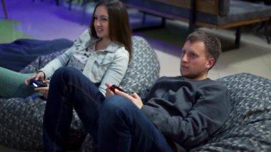 Genç iskambil video oyunu evde çift. Çekim ve oyun kumandasını kullanarak kontrol etmek. Xbox ve Playstation. Kablosuz oyun kontrolcü. Slowmotion atış
