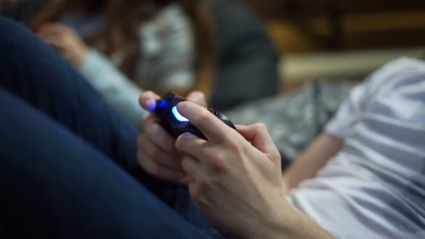 Closeup view of mans hands playing video game at home. Shooting and controlling using the game controller. Xbox and Playstation. Wireless game controler. Slowmotion shot — Stock Video