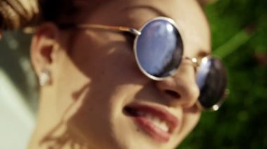 Son moda hippi kız parkta çim üzerinde rahatlatıcı. İyi günler, parlak güneş gözlüğü takıyor keyfi çimenlerin üzerinde döşeme iki hipster kadın yaz yaşam tarzı portresi.